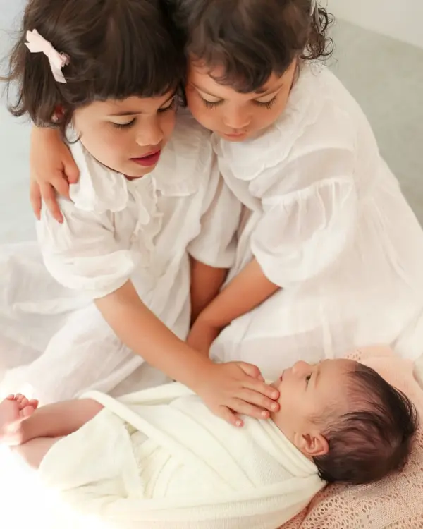 Newborn photography Monsey NY – Two sisters cuddling their newborn sibling