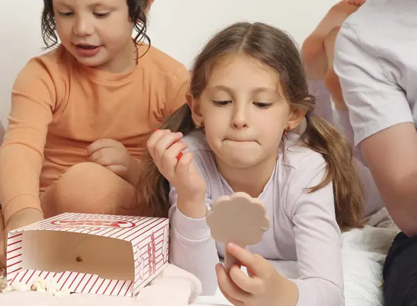 Girl looking into a box of treats with her family, studio photography by Photoholic, Monsey NY